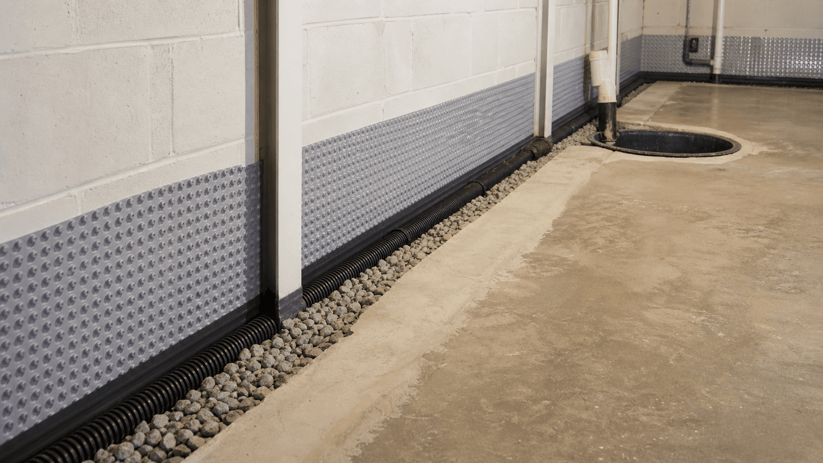 Interior perimeter drain with drainage stone and sump basin in a basement