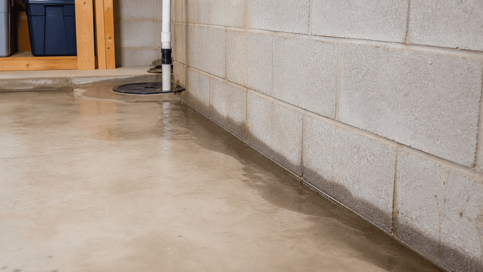 Water along a basement wall-floor joint after rain with a sump area nearby